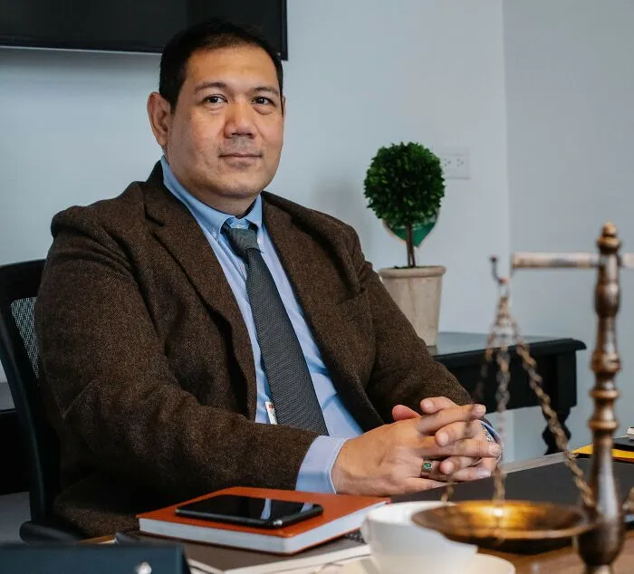 A lawyer sitting at a desk with scales of justice, representing legal loopholes and real laws.