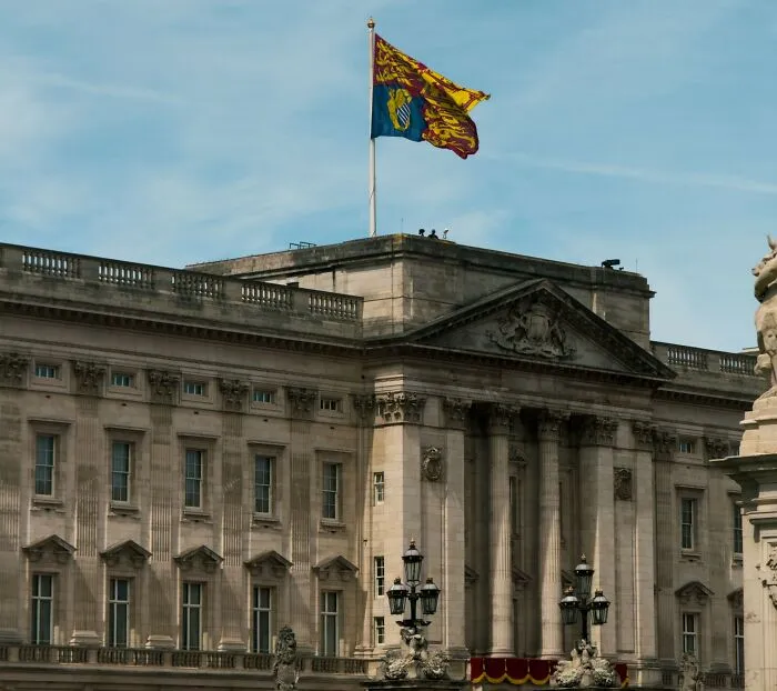 Royal standard flag flying over Buckingham Palace related to real laws