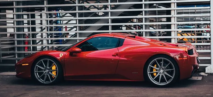 A sleek red sports car parked outside where a slip-up could lead to a massive bill