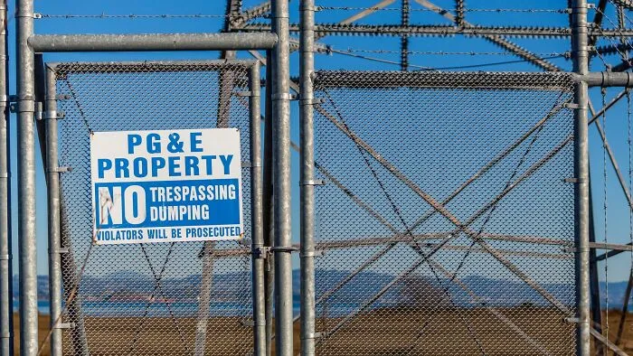 A sign reading PG&E Property on a fence, representing companies people refuse to support.