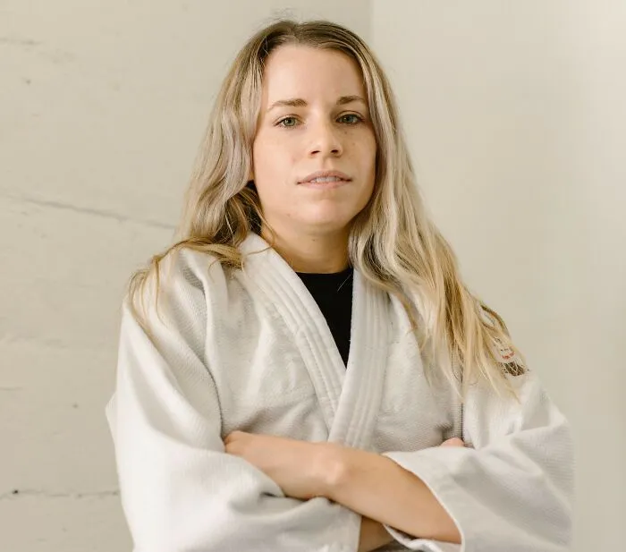 Woman in martial arts uniform showing confidence addressing microaggressions women experience