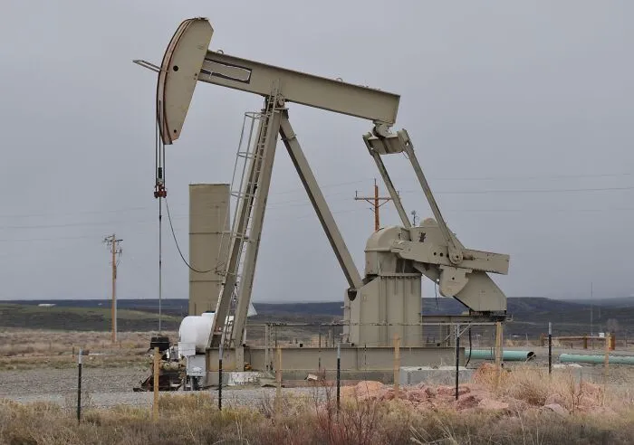 Oil pump jack operating in a field, representing an industrial slip-up turned massive bill