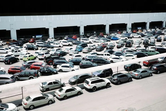 An aerial view of a crowded parking lot packed with cars, illustrating urban life tricks for finding parking spaces.