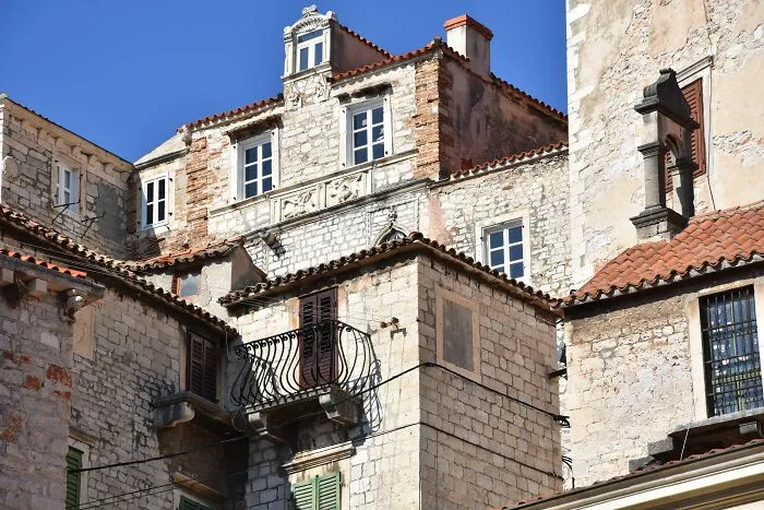 Historic stone buildings in a European town, home to tiny communities with local drama