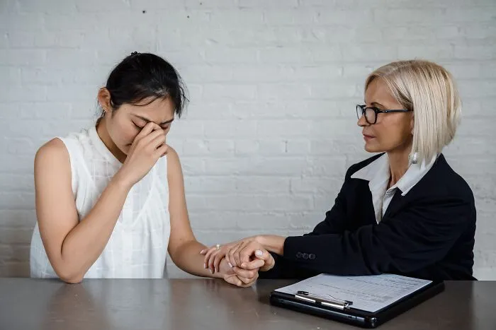 A professional comforting an upset client in an office setting, building or regaining trust.