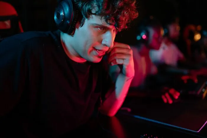 A young man wearing a headset in a dark room keeping personal secrets to himself.