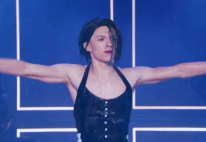 Tom Holland performing energetically, breaking stereotypes as an example of positive masculinity.