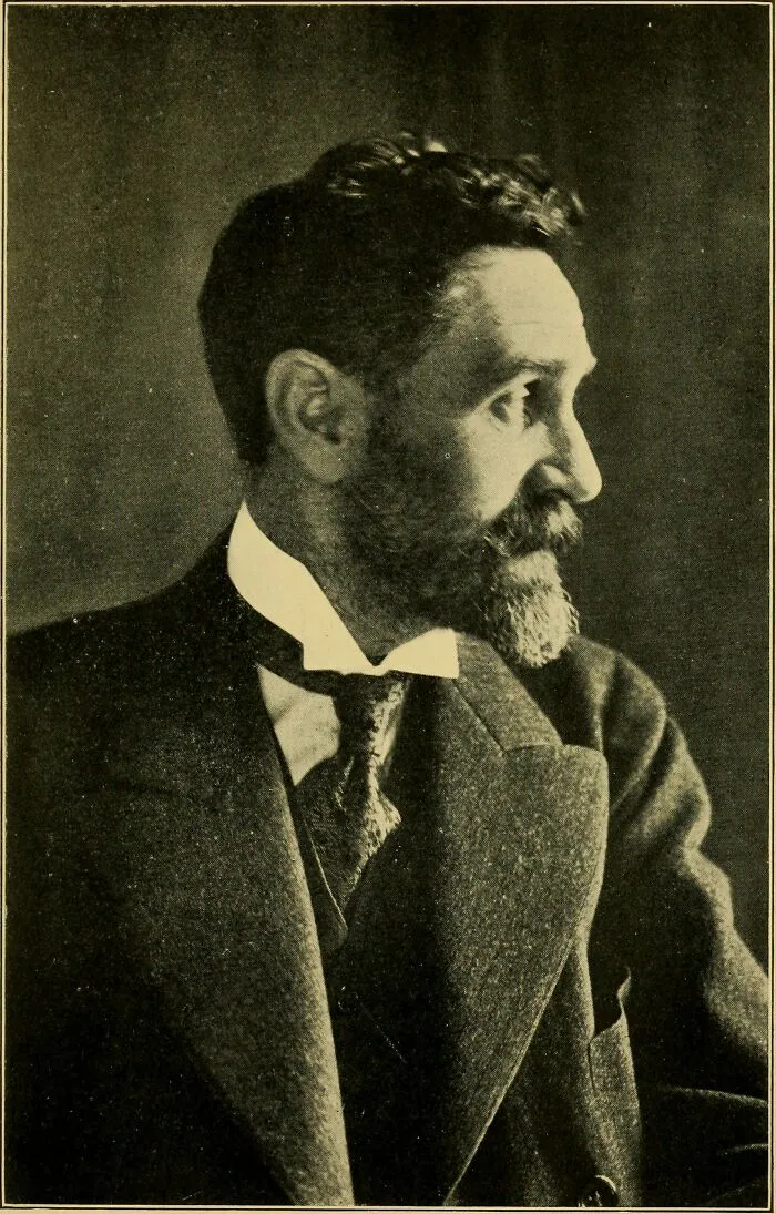 A vintage profile portrait of a bearded man in a suit, reflecting positive masculinity through a calm, gentle gaze.