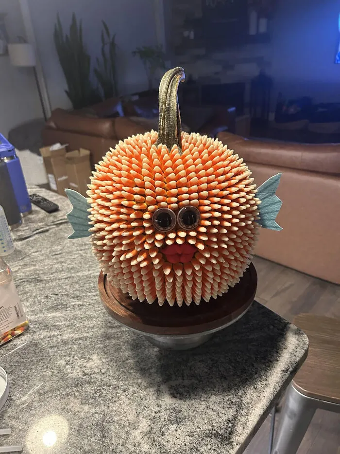 Creative Halloween pumpkin decorated with candy corn to look like a pufferfish.