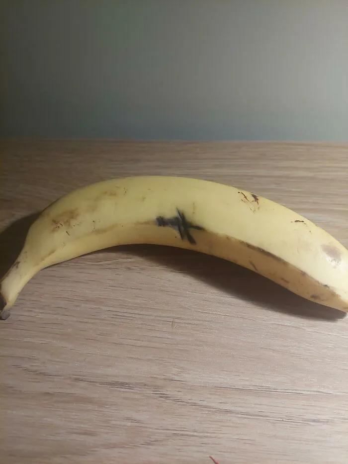 A single yellow banana on a wooden desk given by management as cheap bonuses.