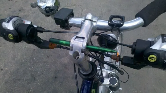 A green ballpoint pen used as a bicycle handlebar stem pin for redneck fixes