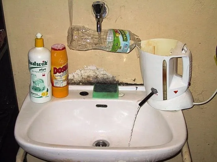 DIY redneck fixes using a plastic bottle and electric kettle to redirect faucet water.
