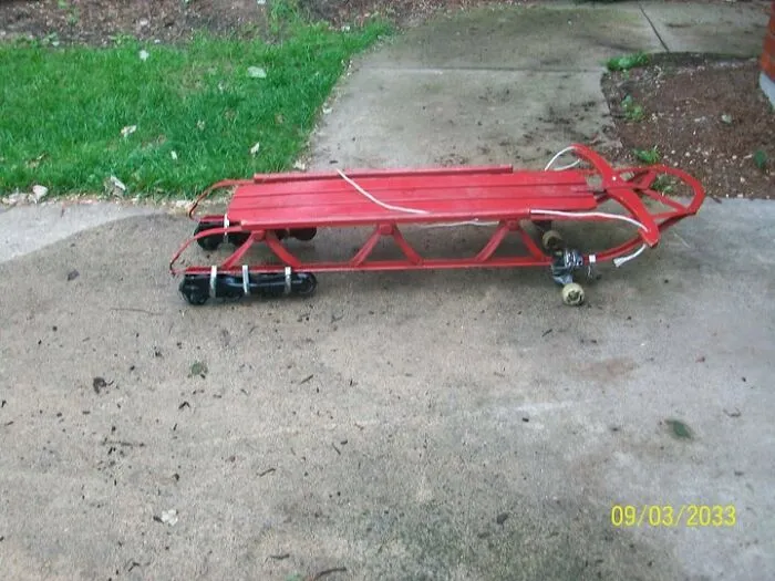Redneck fixes featuring a red wooden snow sled modified with skateboard wheels for pavement.