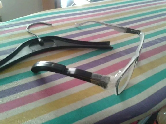 Eyeglasses repaired using part of a plastic clothes hanger as a creative redneck fix.
