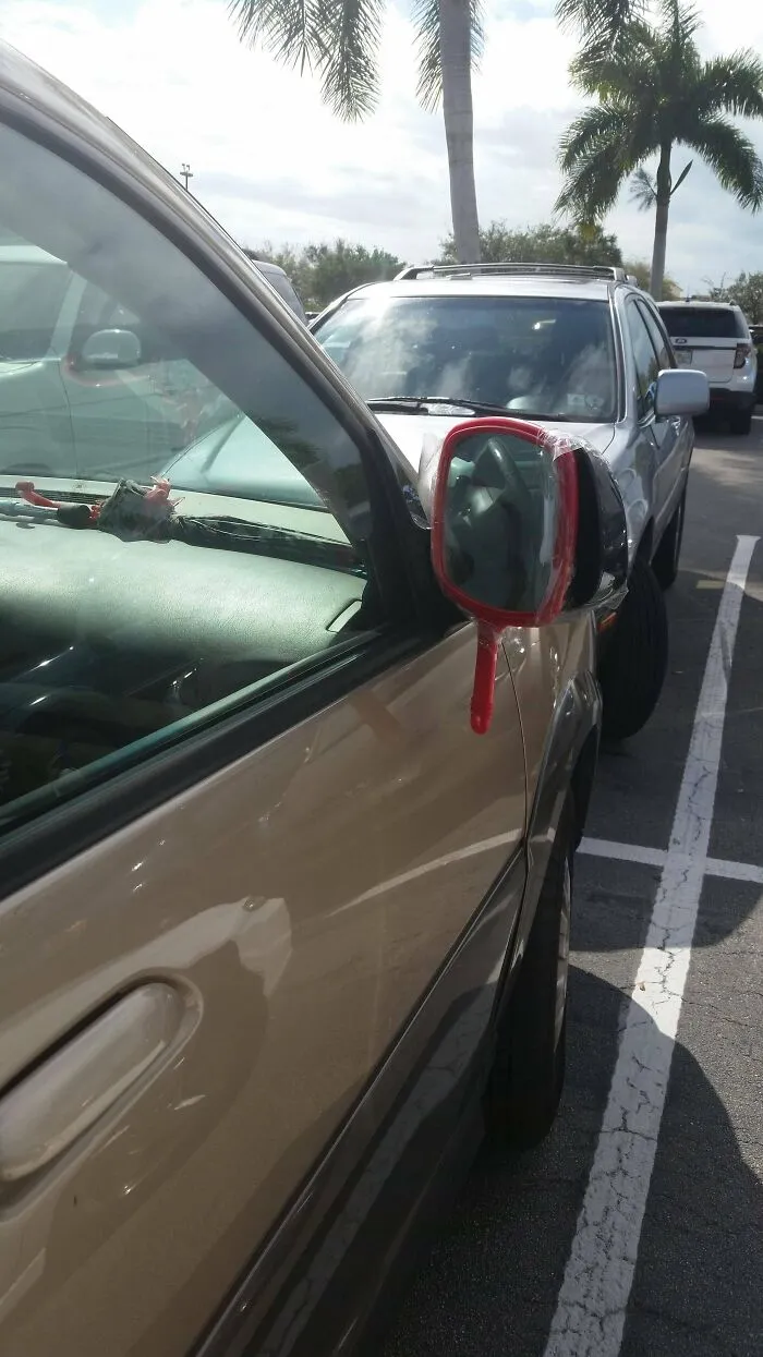 A side mirror replaced with a small hand mirror as a funny redneck fix on a vehicle.