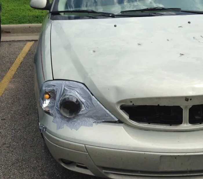 Car headlight repaired using grey duct tape representing ingenious redneck fixes.