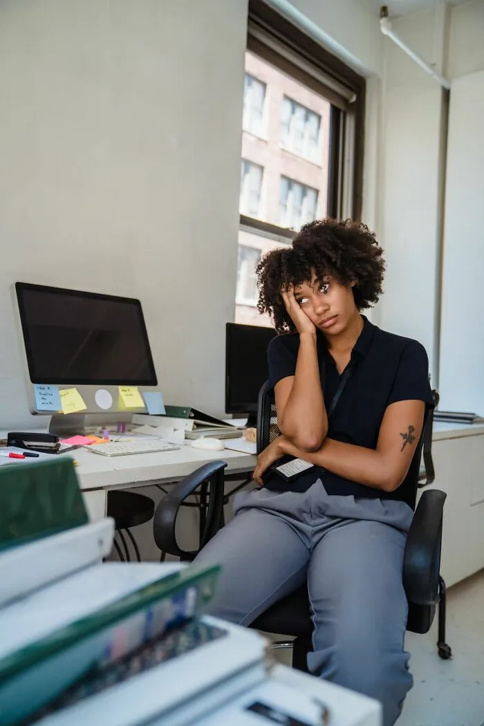 Tired office worker sitting at desk representing bad bonuses and management out of touch with reality