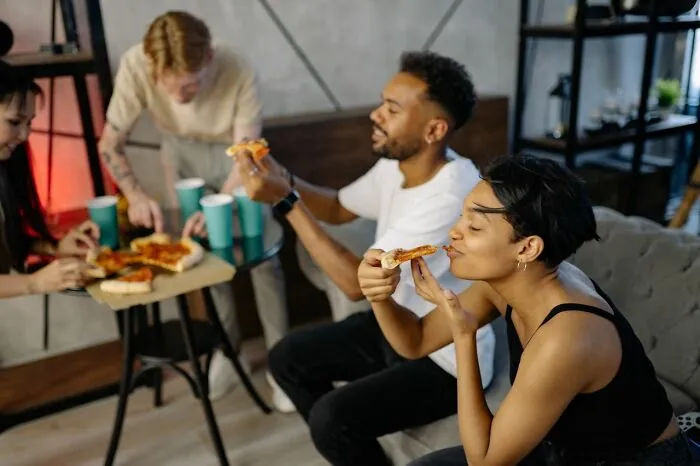 Coworkers sharing a pizza party, representing out of touch bosses and management bonuses.