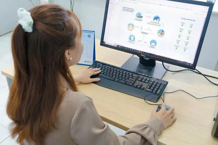 An office employee working on a desktop computer, representing out of touch bosses and management bonuses.