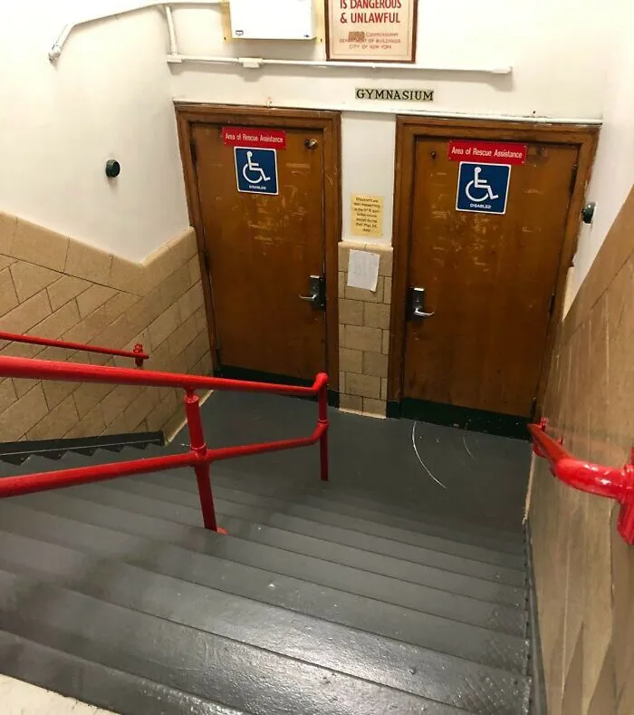 Staircase leading to two accessible gymnasium doors downhill, showing poor design