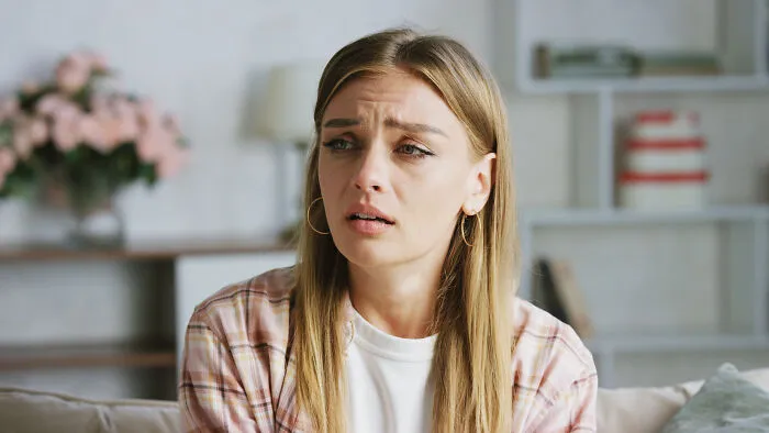 A distressed woman feeling sick sitting indoors after a bad doctor visit