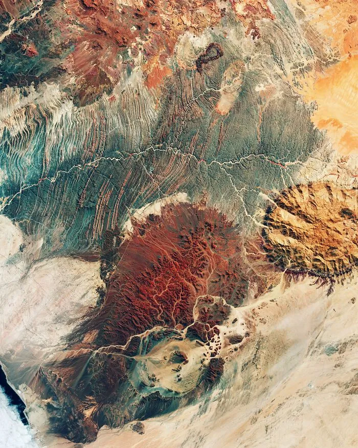 Surreal satellite photos showing colorful red and orange rock formations from above
