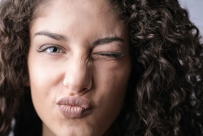 Close-up of woman winking and puckering lips