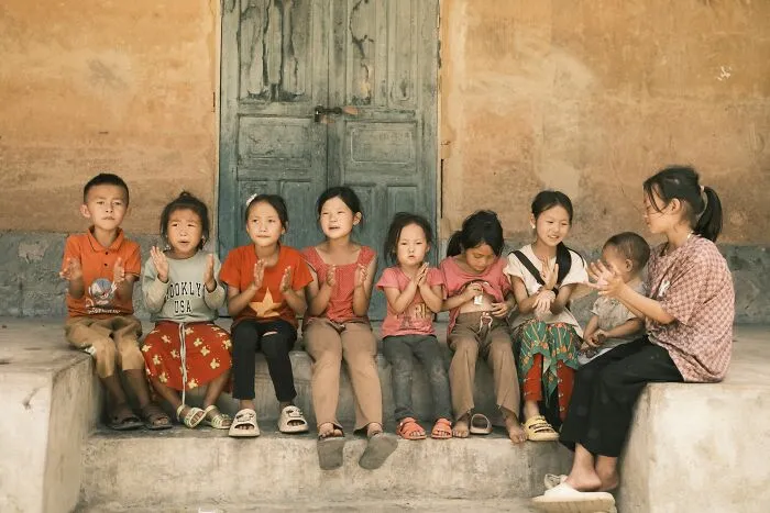 Group of children sitting together outdoors sharing stories and secrets