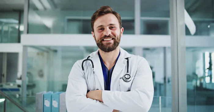 A smiling male doctor standing in a hospital clinic