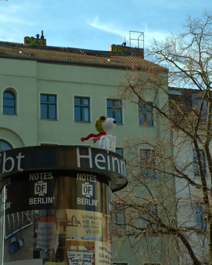 Snoopy art collective street installation on top of a billboard structure on city streets