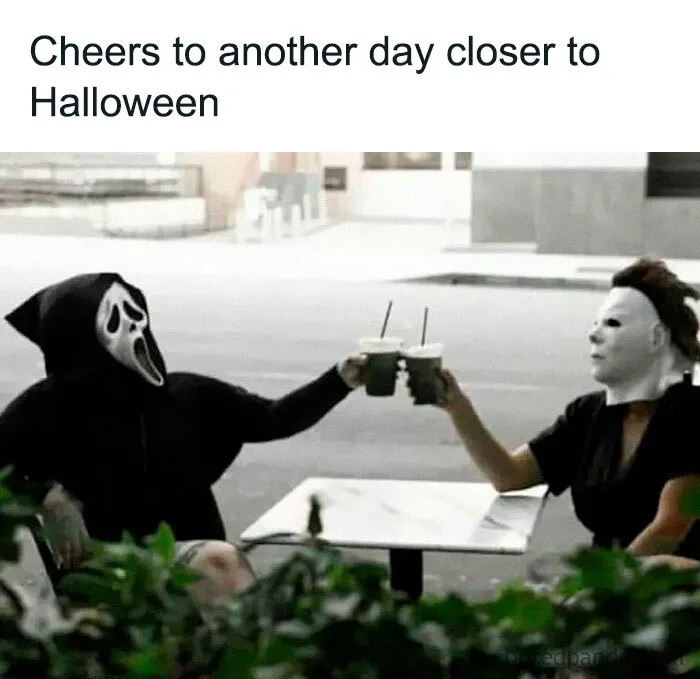Spooky season meme of Ghostface and Michael Myers clinking iced coffee drinks outdoors.