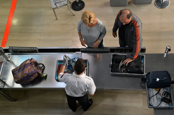 An overhead view of passengers and security personnel, illustrating travelers stopped by TSA