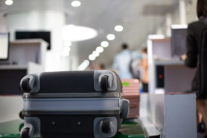 A close-up of a suitcase on an airport conveyor belt, symbolizing luggage check for travelers stopped by TSA