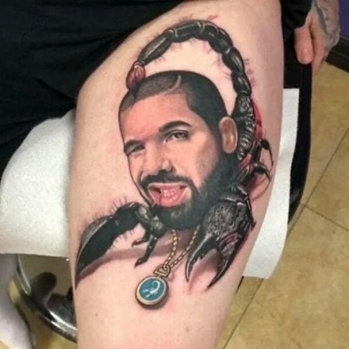 Tatuaje de escorpión con rostro humano en pierna, ejemplo de personas con tatuajes horribles sin darse cuenta.