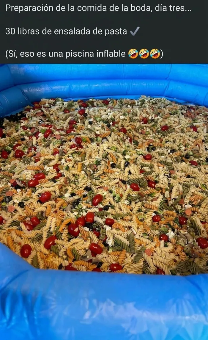 Piscina inflable llena de ensalada de pasta servida en bodas al aire libre.