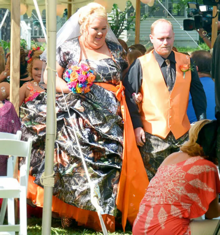 Novios camuflados caminando al altar en una de las bodas más insólitas.