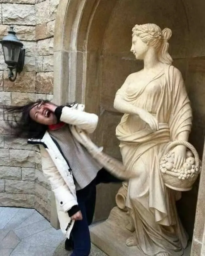Una de las imágenes tan divertidas como disparatadas de una mujer fingiendo ser abofeteada por una estatua de piedra