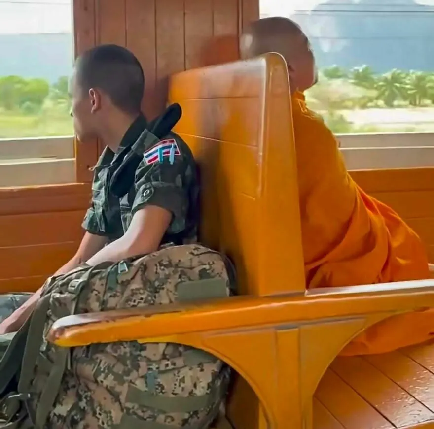 Militar y monje sentados juntos en un tren, escena de imágenes confusas.