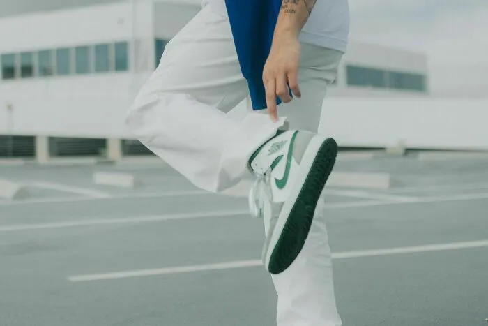 Persona vistiendo zapatos deportivos y pantalones blancos en azotea