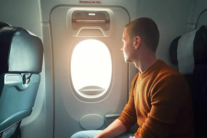 Pasajero mirando por la ventana del avión