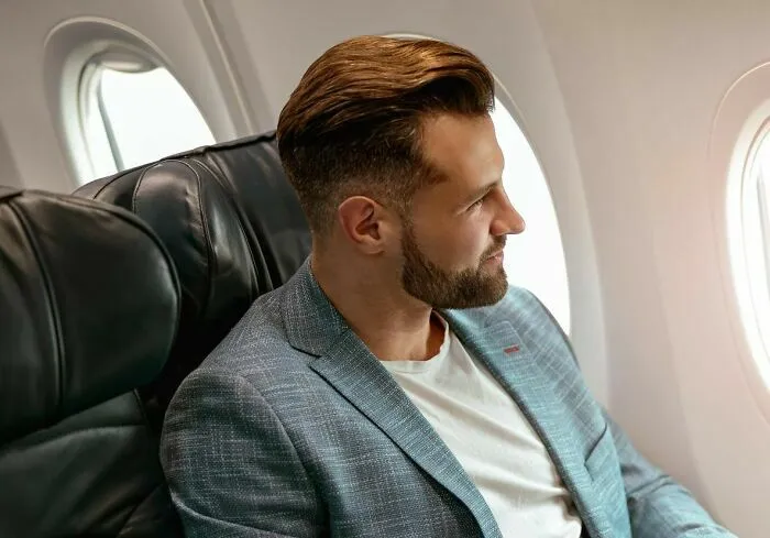 Hombre mirando por la ventana durante vuelo en avión