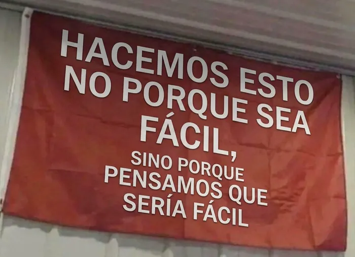 Bandera roja con un texto irónico en español, perfecta entre estas publicaciones divertidas para relajarte.