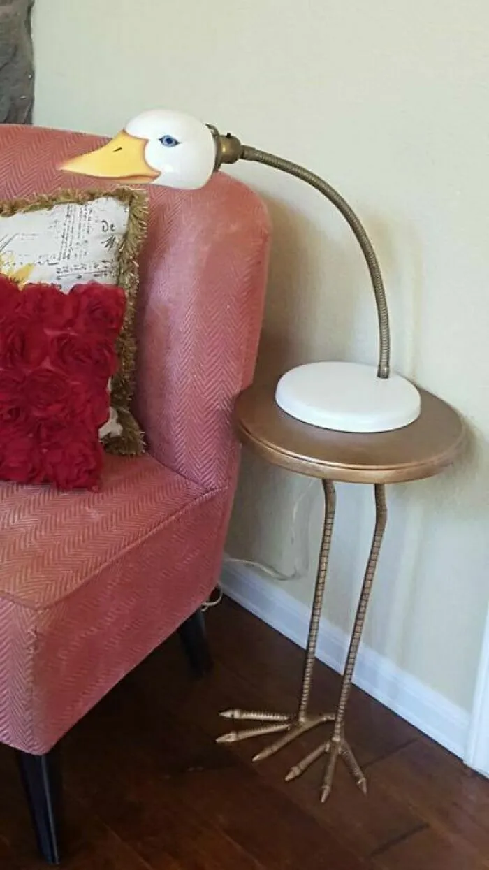 Lampara con forma de cabeza de pato sobre mesa auxiliar con patas de ave, un increible talento de decoracion.