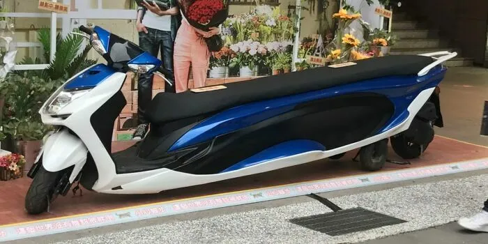 Motoneta de diseño alargado azul y blanco, reflejo de increíble talento de ingeniería.