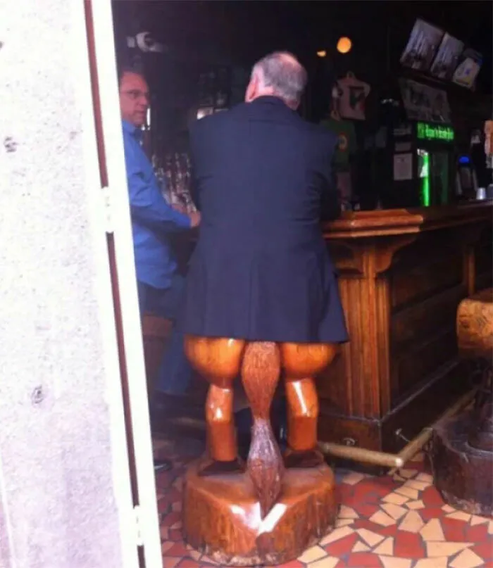 Señor sentado en un taburete de bar con forma de patas traseras de animal, desperdiciaron su talento en carpintería.