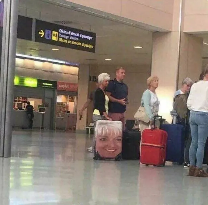 Mujer en el aeropuerto con una maleta que tiene su propia cara impresa, desperdiciaron su talento en diseño.