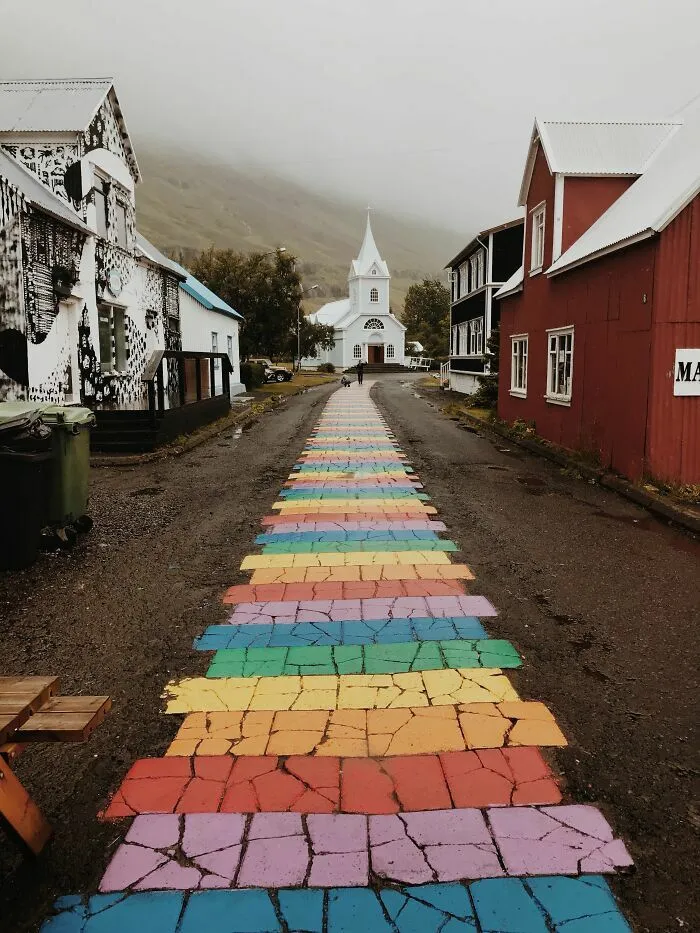Un camino peatonal pintado con los colores del arcoíris en un pueblo, entre las cosas curiosas del diseño urbano.