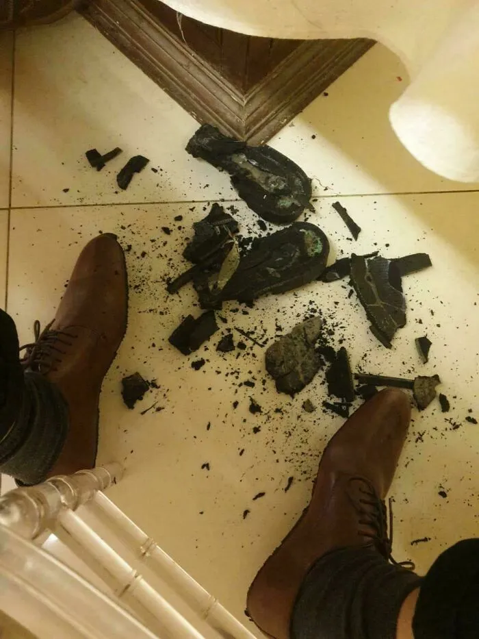 Zapatos elegantes con la suela rota en pedazos en el suelo, mostrando que siempre puede empeorar.