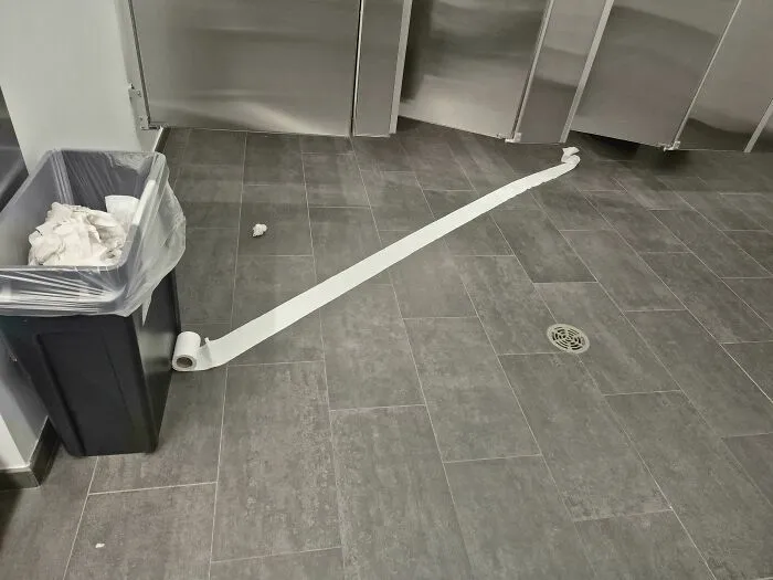 Rollo de papel higiénico desenrollado en el suelo de un baño público para ilustrar que siempre puede empeorar
