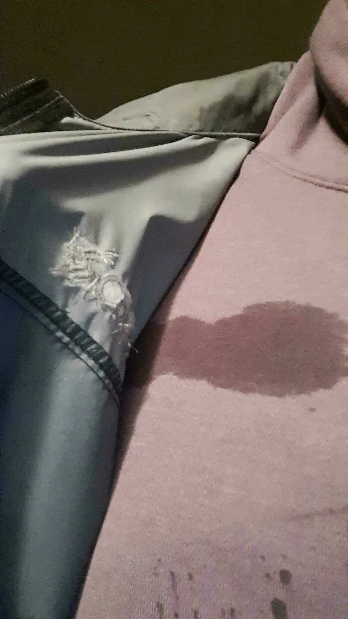 Chaqueta rota y mancha húmeda en la sudadera mostrando un mal día.